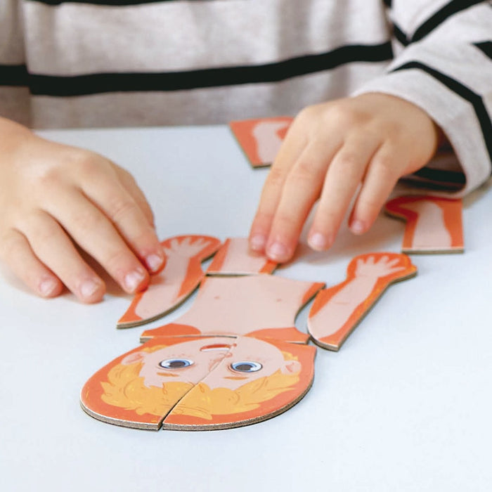 Child playing with a lion-shaped puzzle on a white surface