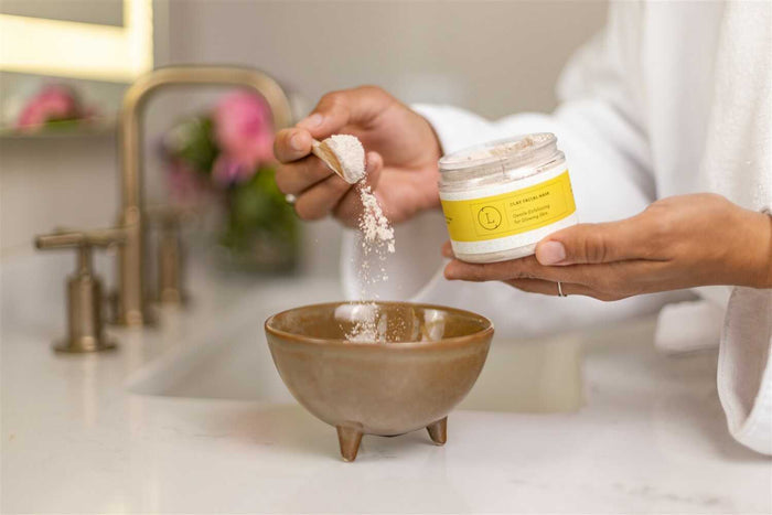 Natural Clay Facial Mask - Woman scooping natural clay mask from jar with spoon | Lizush