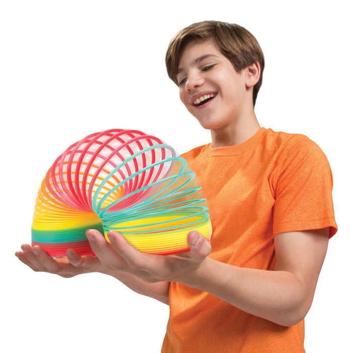 Child playing with a Slinky on a white background