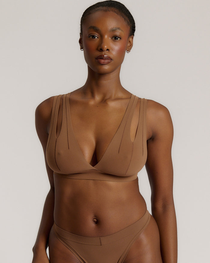 Woman wearing a brown bra against a neutral background