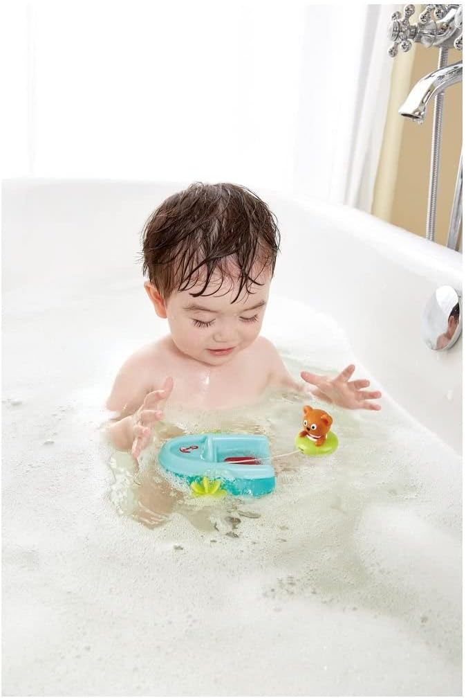 Child in soapy bathtub playing with tubing pullback boat.