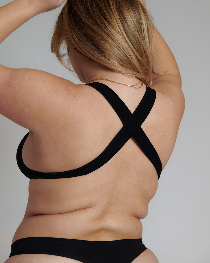 A person wearing an x back system, modeling the back to show the backband free alternative.