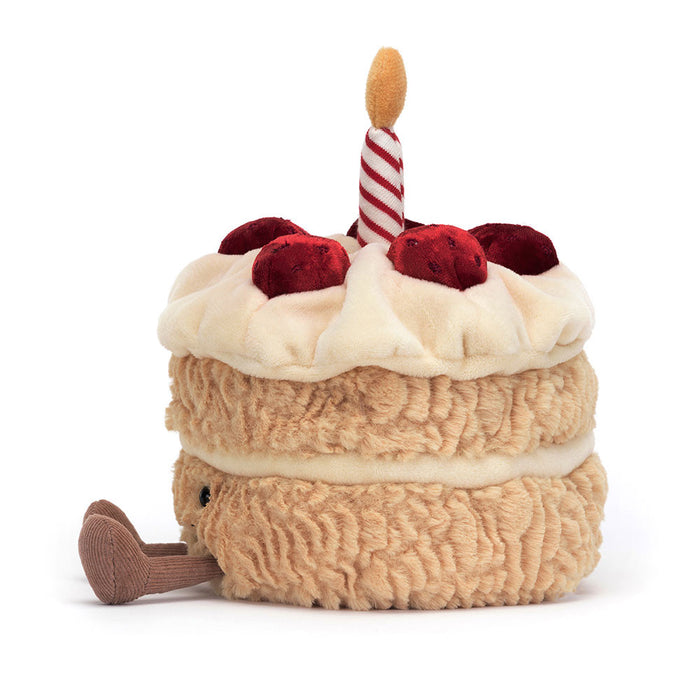 Side view of a plush birthday cake on a white background.