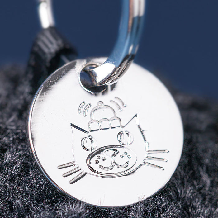 Silver Jellycat pendant on a dark fabric background