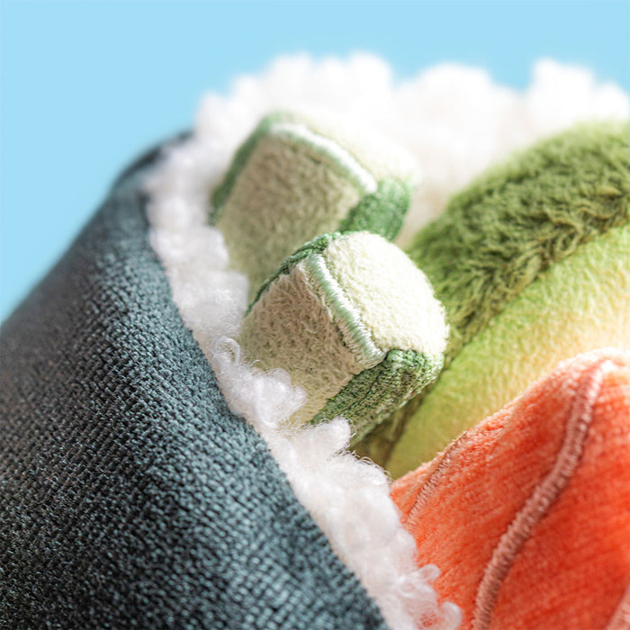 Close-up of a textured fabric with green, orange, and white patterns against a blue background