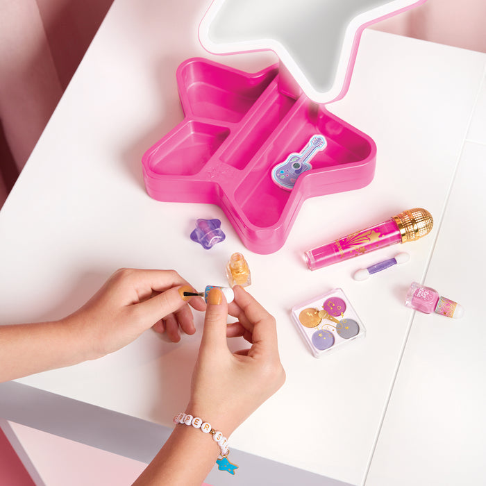 Young girl painting her nails with contents of the Glam Cosmetic Studio on a white table