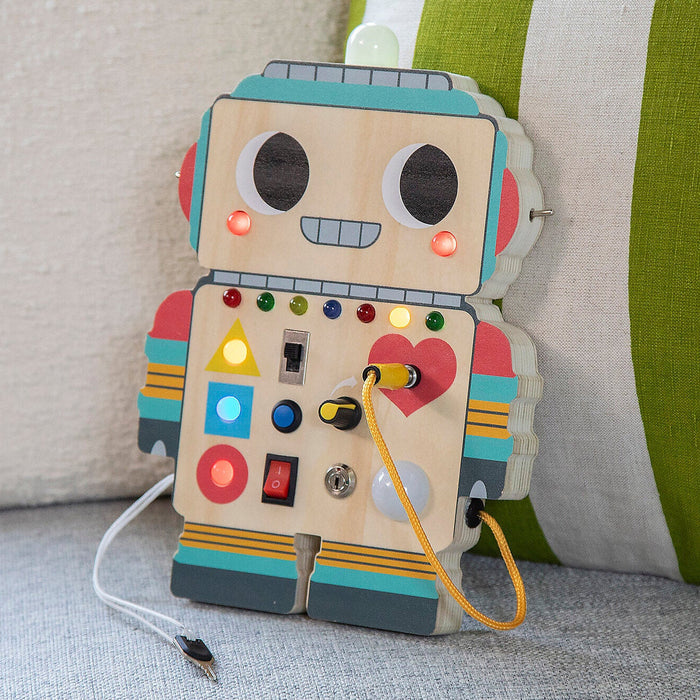 Colorful robot toy with lights and buttons on a textured surface