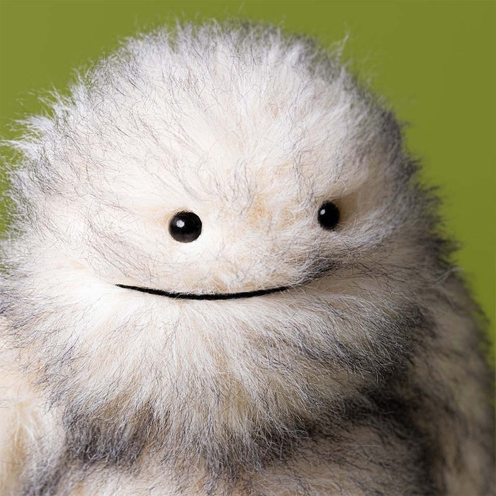 Close up of Jellycat Bretti Yeti's face on a green background