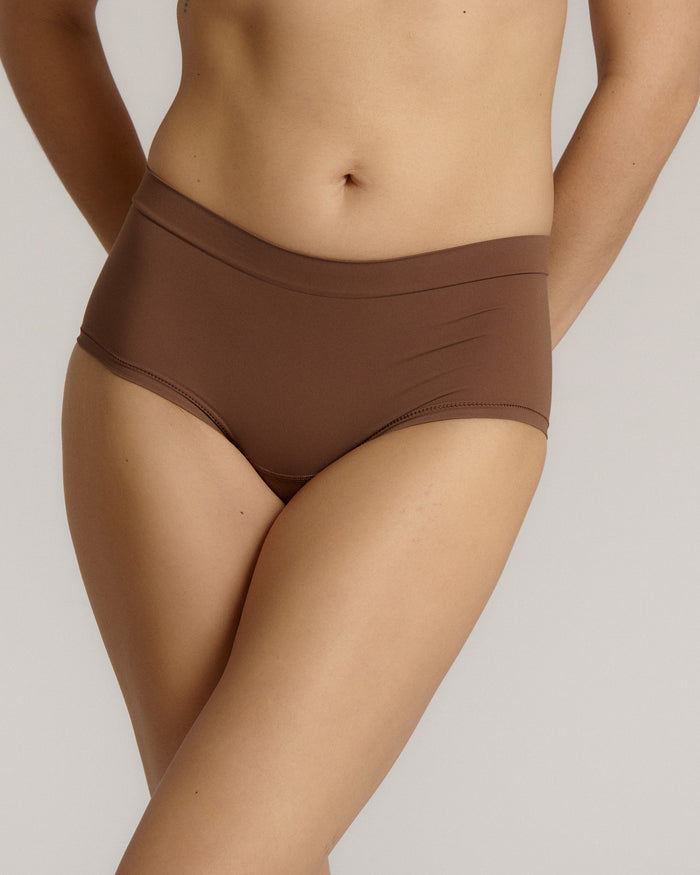 A mid-rise brown brief underwear with a seamless design, showing the waistband and part of the leg openings.
