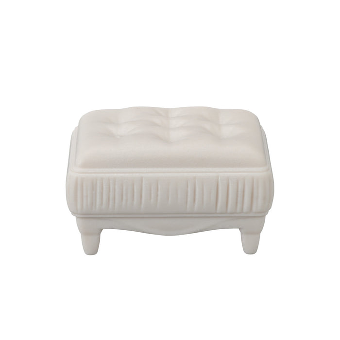 White ottoman with a textured surface on a white background