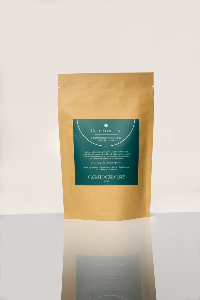 A brown pouch packaging with a green label that reads 'Calm Your T*ts Bath Salts' from the brand Complex Creatures.