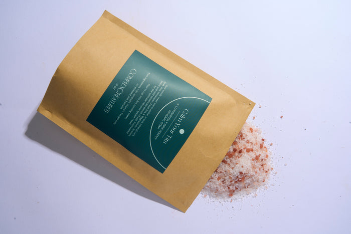A brown pouch packaging with a green label that reads 'Calm Your T*ts Bath Salts' from the brand Complex Creatures.