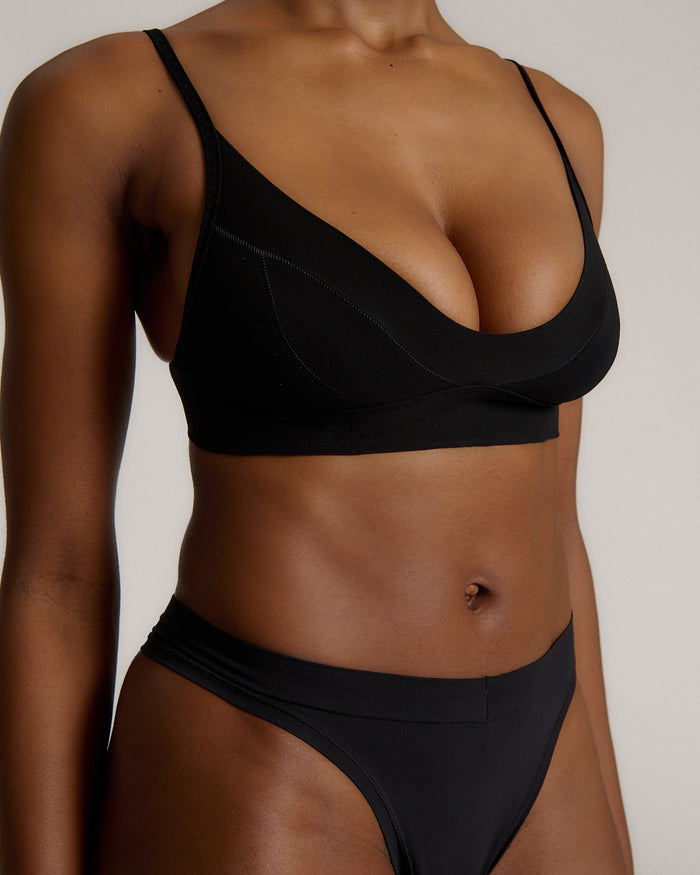 Person wearing a black cami system against a plain background
