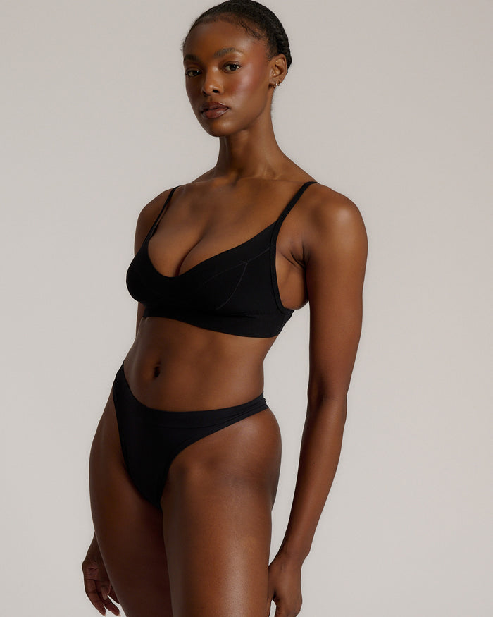 Person wearing a black cami system against a plain background
