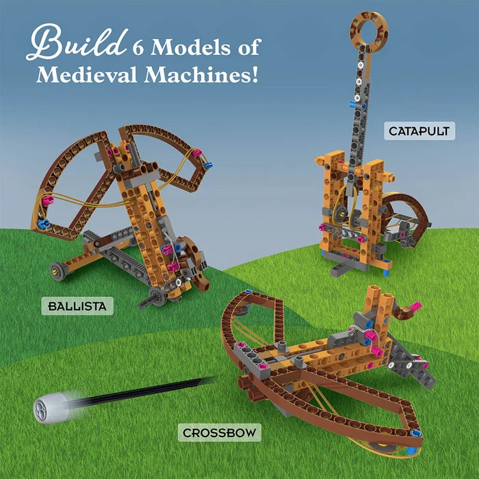Toy model set of medieval machines including a ballista, catapult, and crossbow on a grassy field with a blue sky.