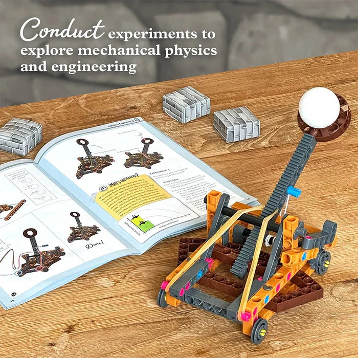 Toy physics experiment set on a wooden table with a book and materials.