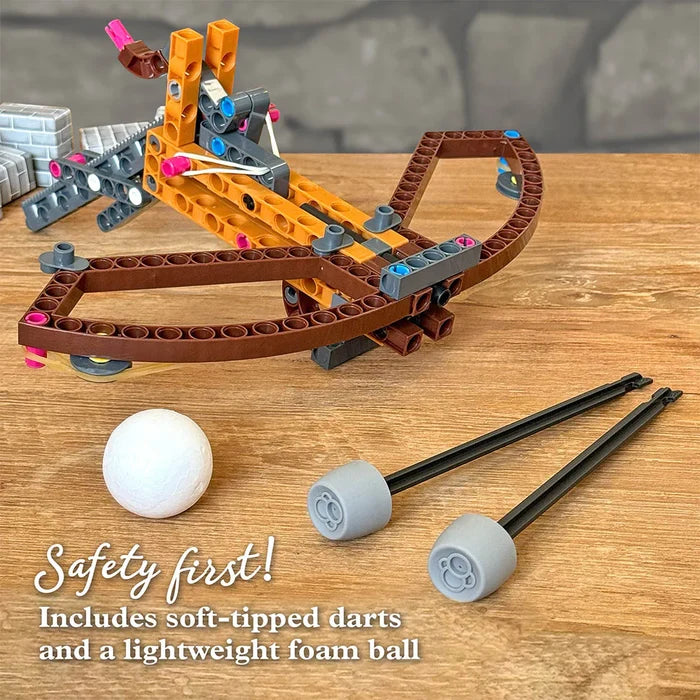 Toy crossbow set with soft-tipped darts and a foam ball on a wooden surface.