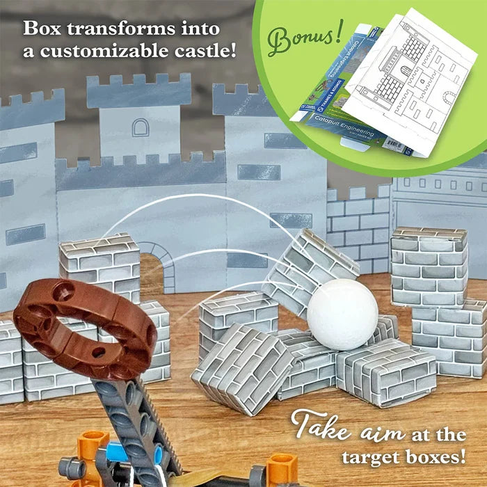 Toy castle set with customizable features and target boxes on a wooden surface.