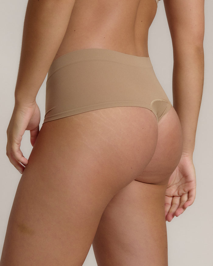 A pair of beige, mid-rise women's underwear.