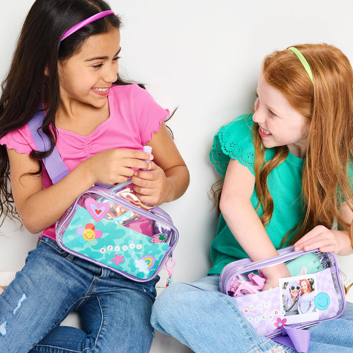 Two young girls playing with their Belt Bags seated agains a white background