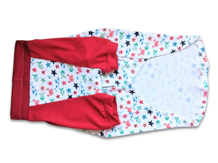 Underbelly profile of Jax & Molly's dog pajamas, decorated with sea creatures and complemented by red sleeves.