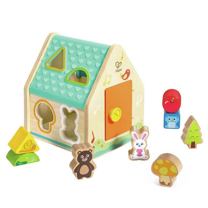 Wooden toy house shape sorter with various shapes and animals on a white background