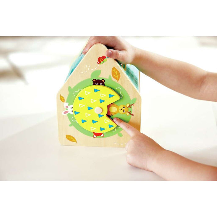 Child holding the Critter House Shape Sorter pointing at a picture of a deer