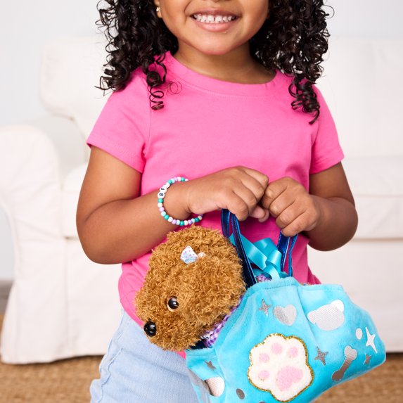 Child holding a blue bag with a brown dog plush inside, wearing a pink shirt and blue jeans.
