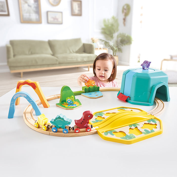 A child playing with the dino train set in a living room on a white table