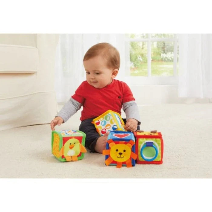 Baby playing with colorful blocks on a light-colored floor.