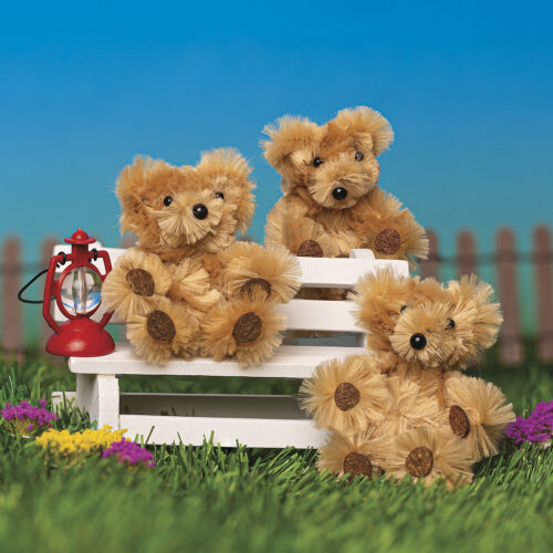 Three teddy bears sitting on a white bench with a red lantern in a garden setting.