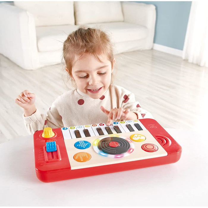Child playing with a toy keyboard in a room with a white couch.