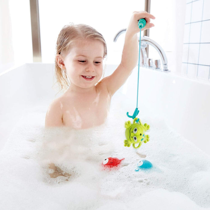 Child playing with bath toys in a bathtub filled with bubbles