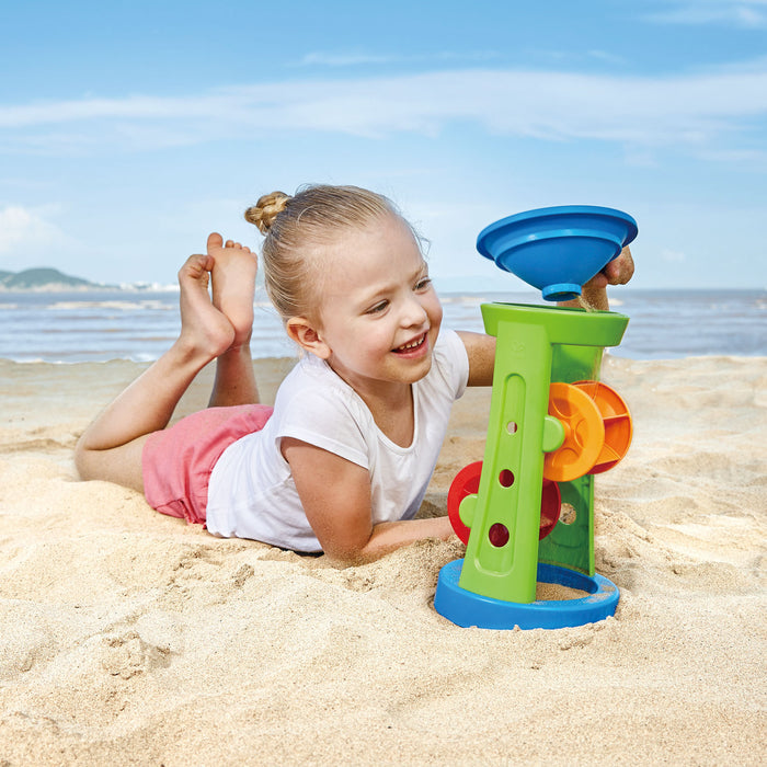 Child playing with colorful sand toys on a sandy beach
