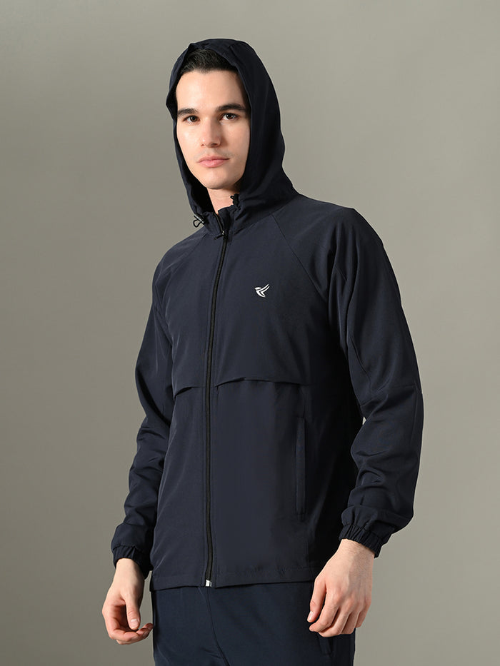 Person wearing a black jacket with a hood on a gray background