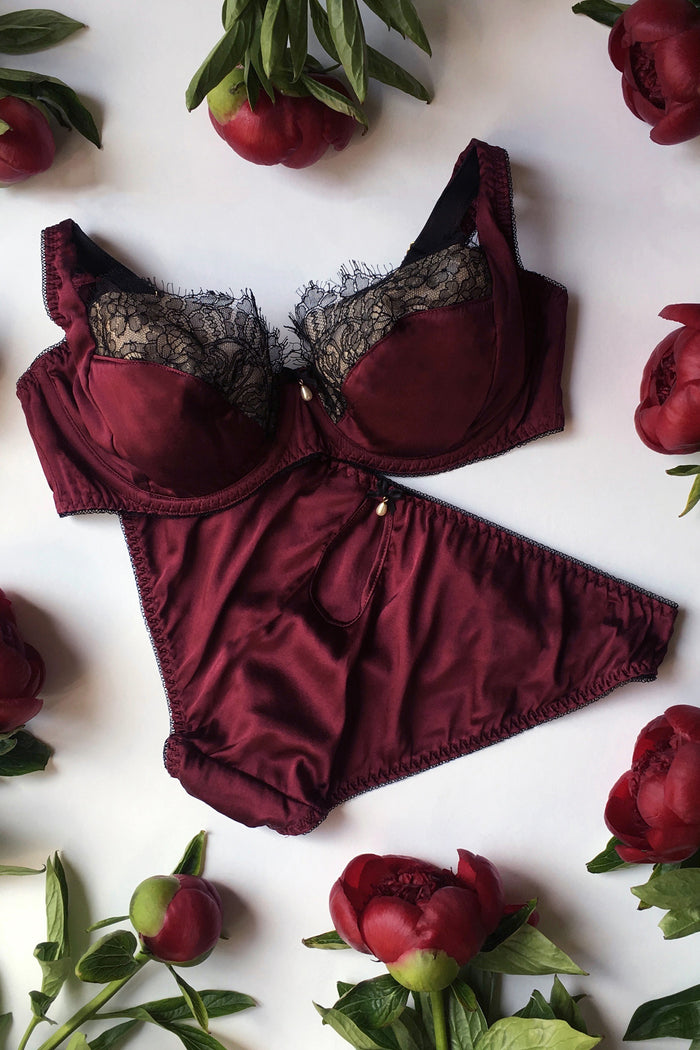 Silk bra and brief in burgundy silk and black lace with pearl details flatlay