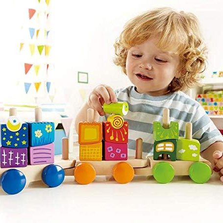 Child playing with a colorful wooden toy train set