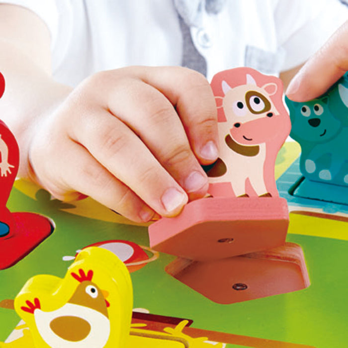 Child's hand holding a wooden cow puzzle piece