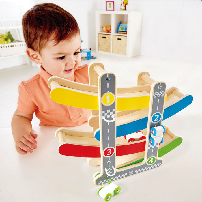 Child playing with the Fast Flip Racetrack on a white table