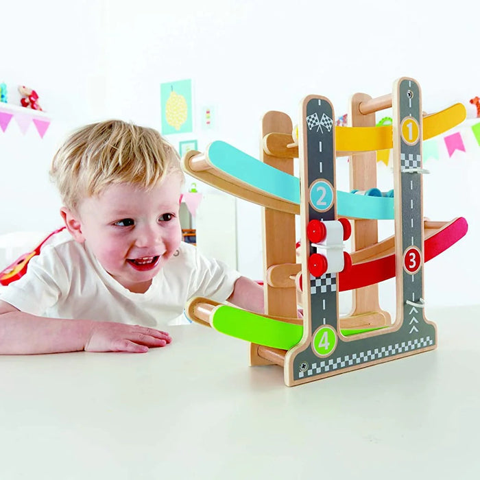 Little boy playing with the Flip Fast Race Track on a white table