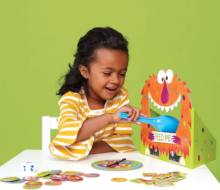 Child playing Feed The Woozle on a white table.