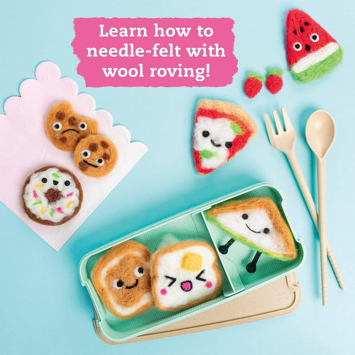 A styled flat-lay of cute needle-felted food items arranged on a light blue background, including a mint green divided lunch box with sandwich faces, a watermelon slice, strawberries, cookies, pizza slice, and utensils. A pink text box reads, 'Learn how to needle-felt with wool roving!'.