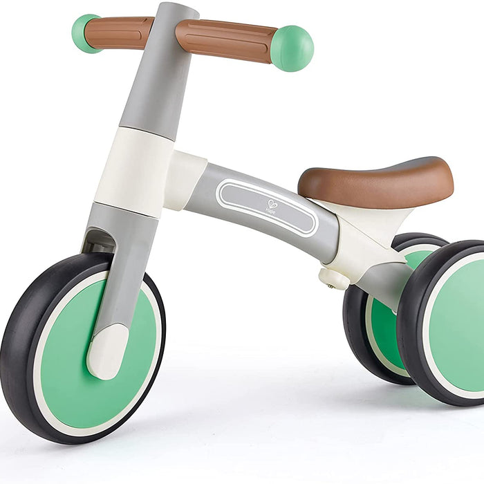 Children's balance bike with green wheels and brown handlebar grips on a white background