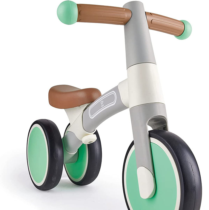 Children's balance bike with green and brown accents on a white background