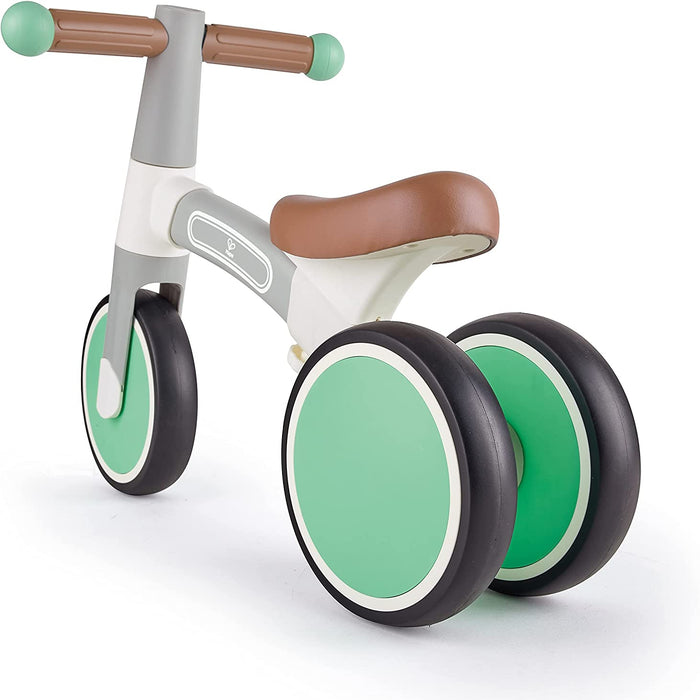 Children's balance bike with green wheels and brown handlebar and seat on a white background