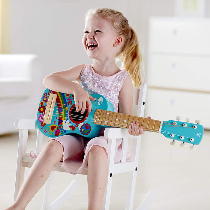 Young girl playing a colorful toy guitar in a bright room