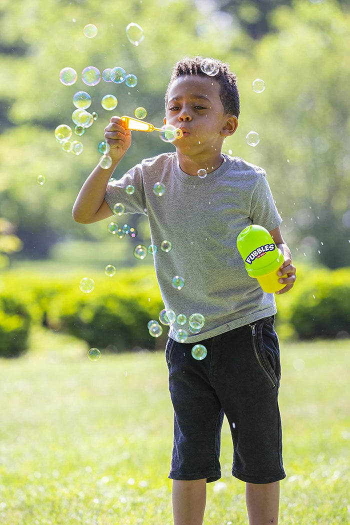 Child blowing bubbles outside