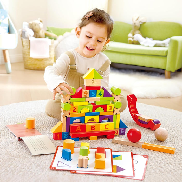 Child playing with colorful wooden building blocks in a living room.