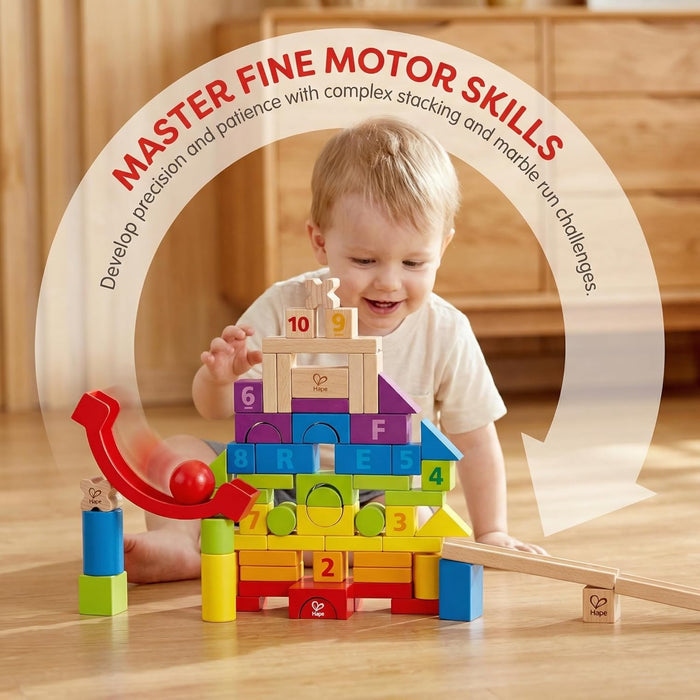 Child playing with colorful building blocks on a wooden floor, with text about mastering fine motor skills.