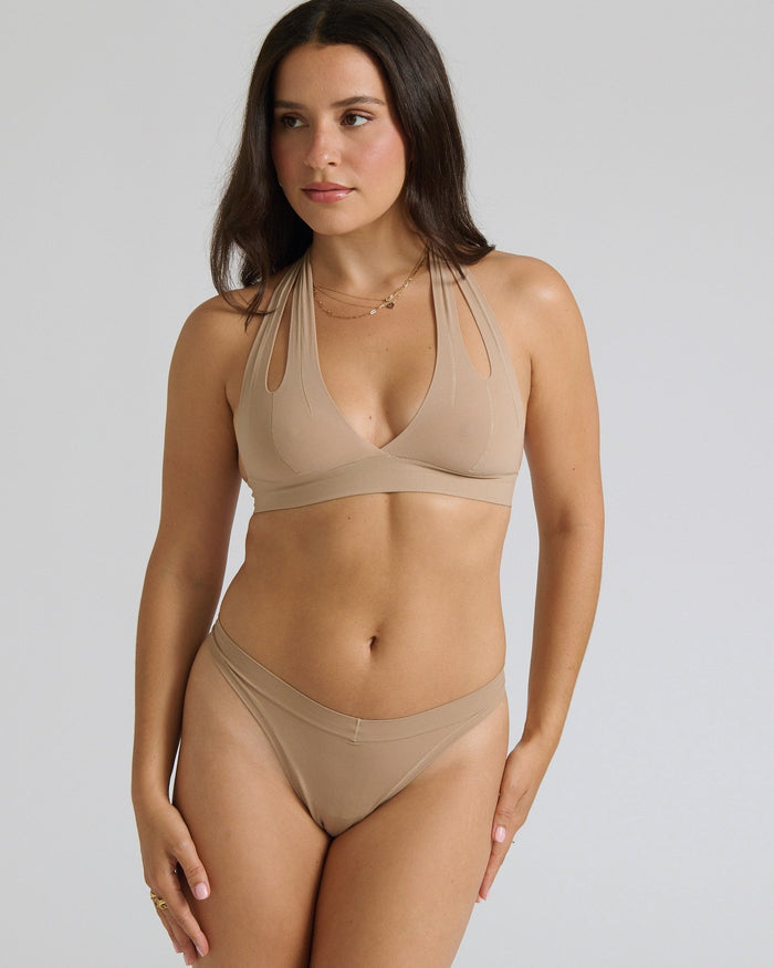 Beige halter system worn by a person on a plain background